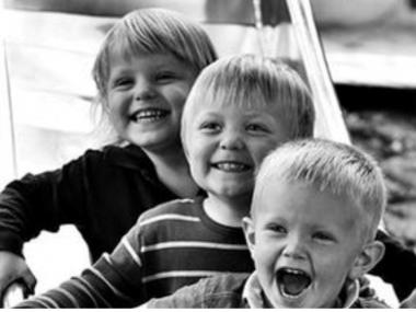 Tre børn der griner